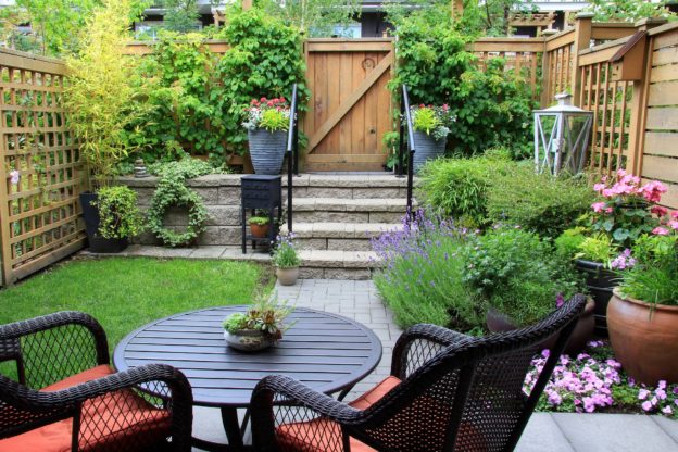 A garden with a garden furniture set and several pot plants to make it interesting and spacious.